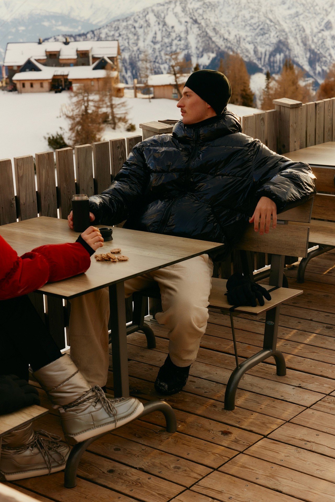 A person sitting outdoors in a snowy mountain setting.