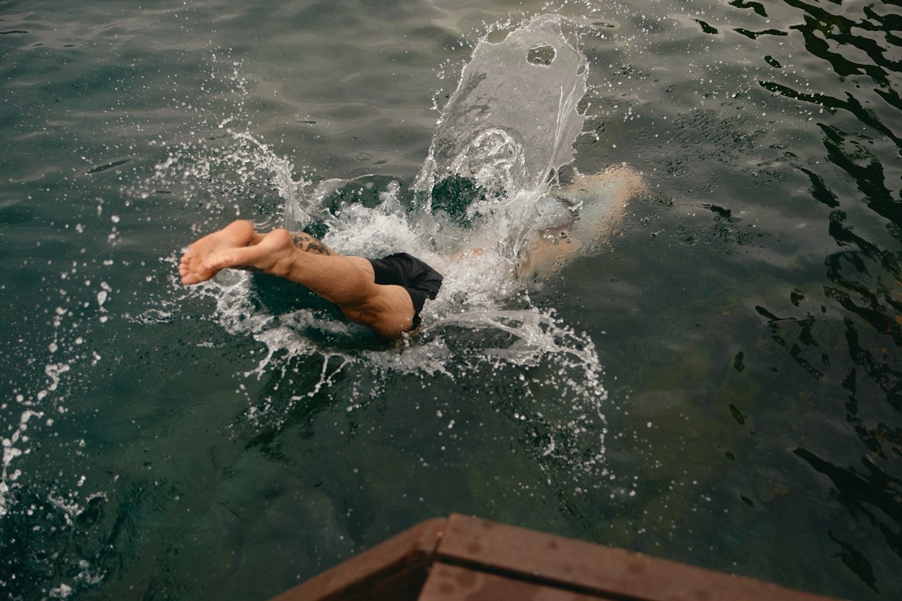 A swimmer entering the water with a strong splash.