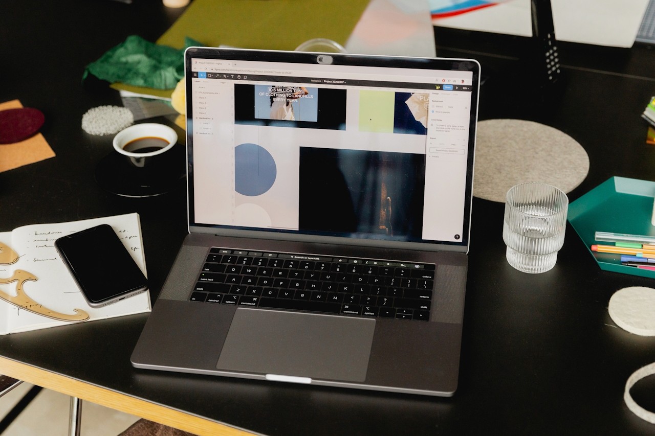 A laptop open on a desk with a design app on the screen.