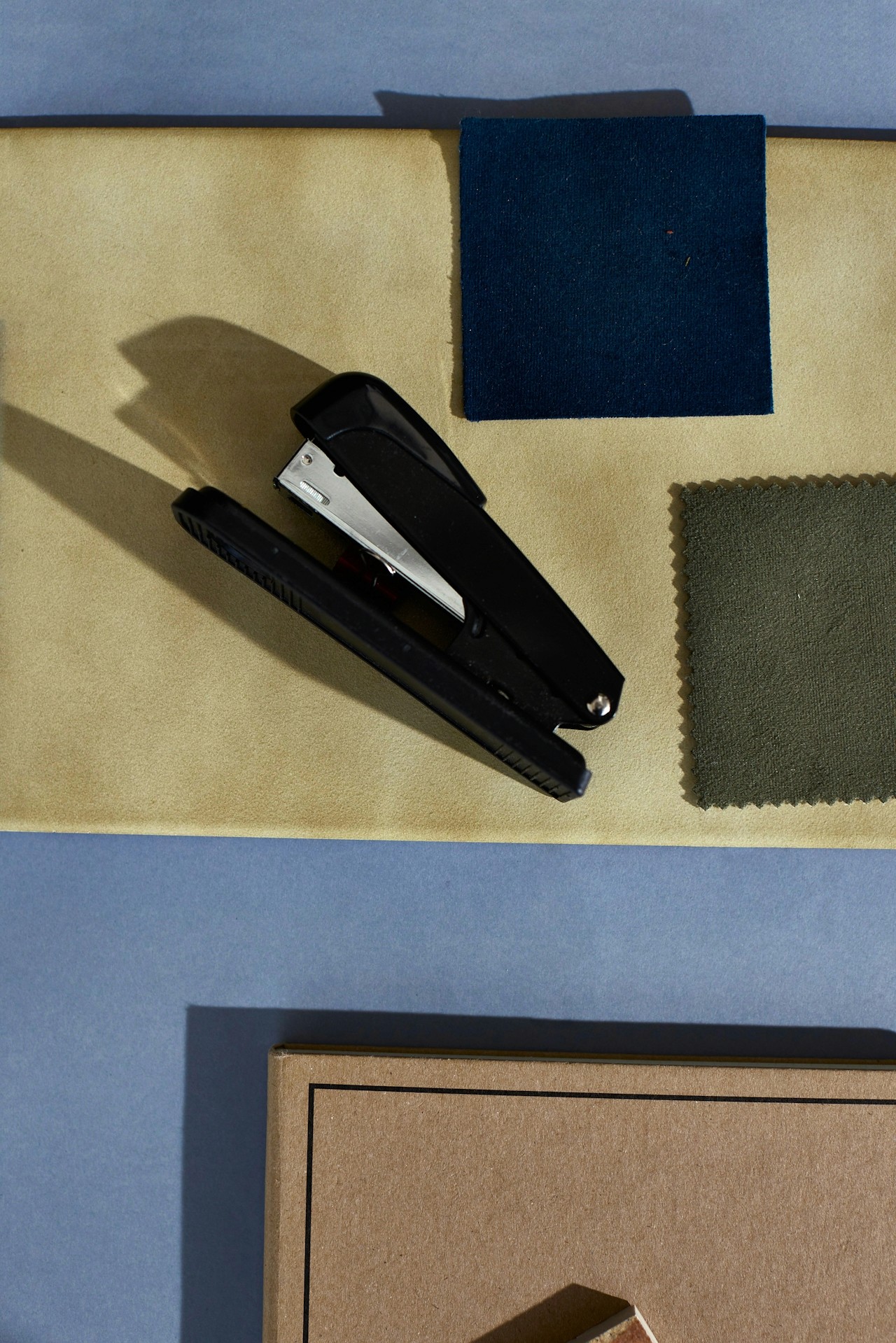 A black stapler on a table.