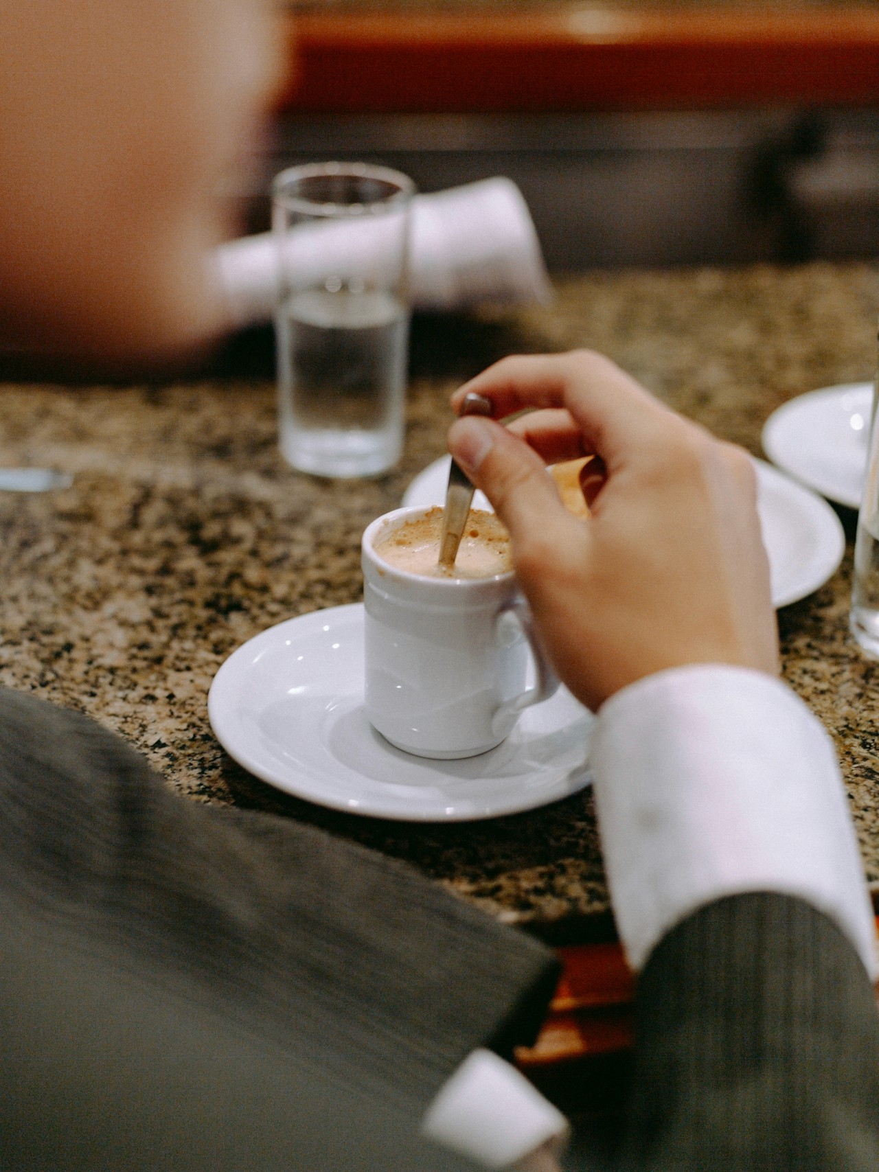 A person stirring tea in a cup.
