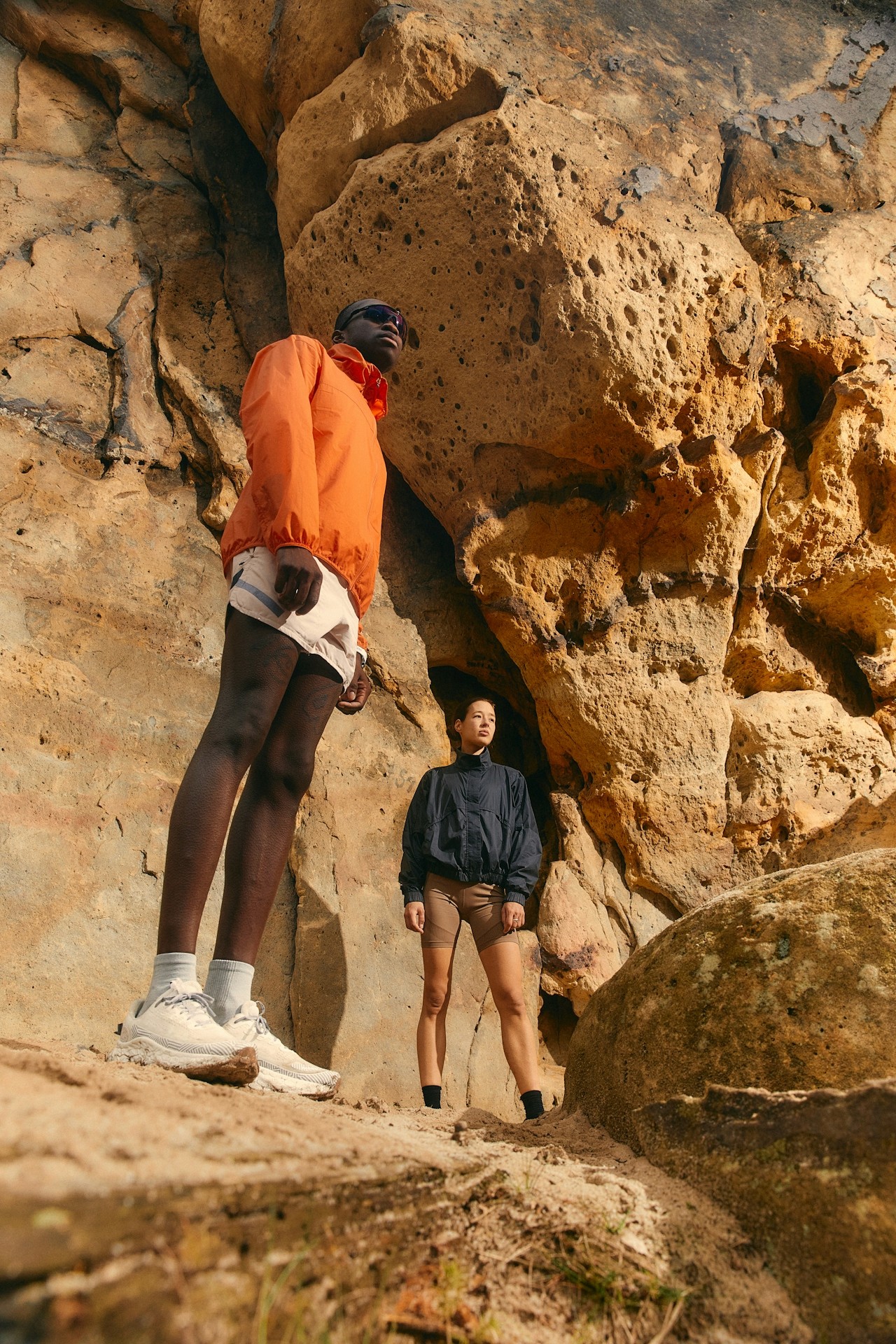 Two friends standing together on a rocky mountain.