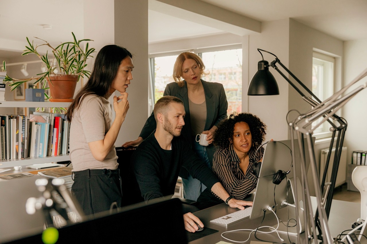 A team reviewing work on a screen.