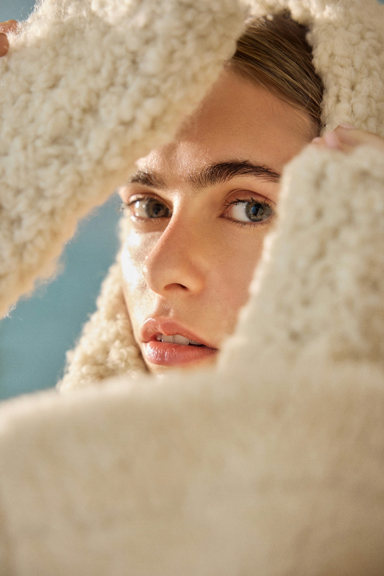 A well-composed photograph of a girl behind rocks.