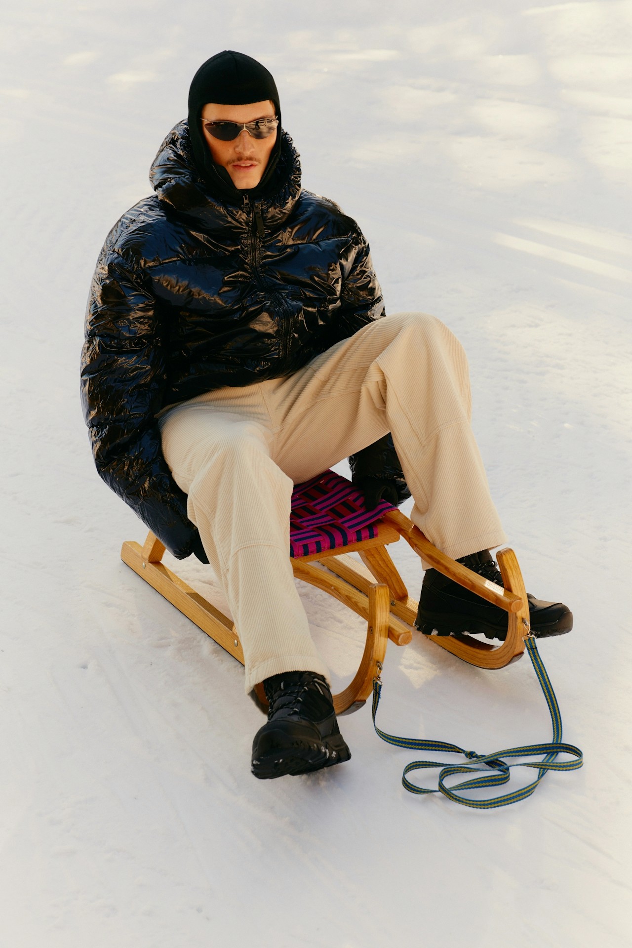 A man sitting on a cart in a snowy setting.