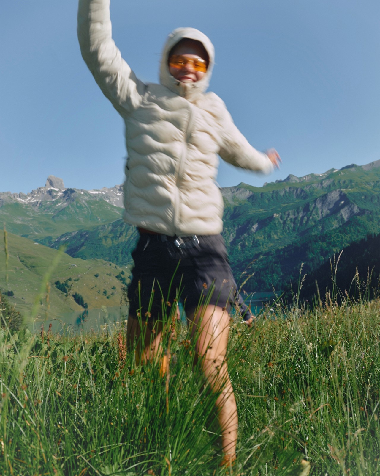 A man running through green mountain terrain.