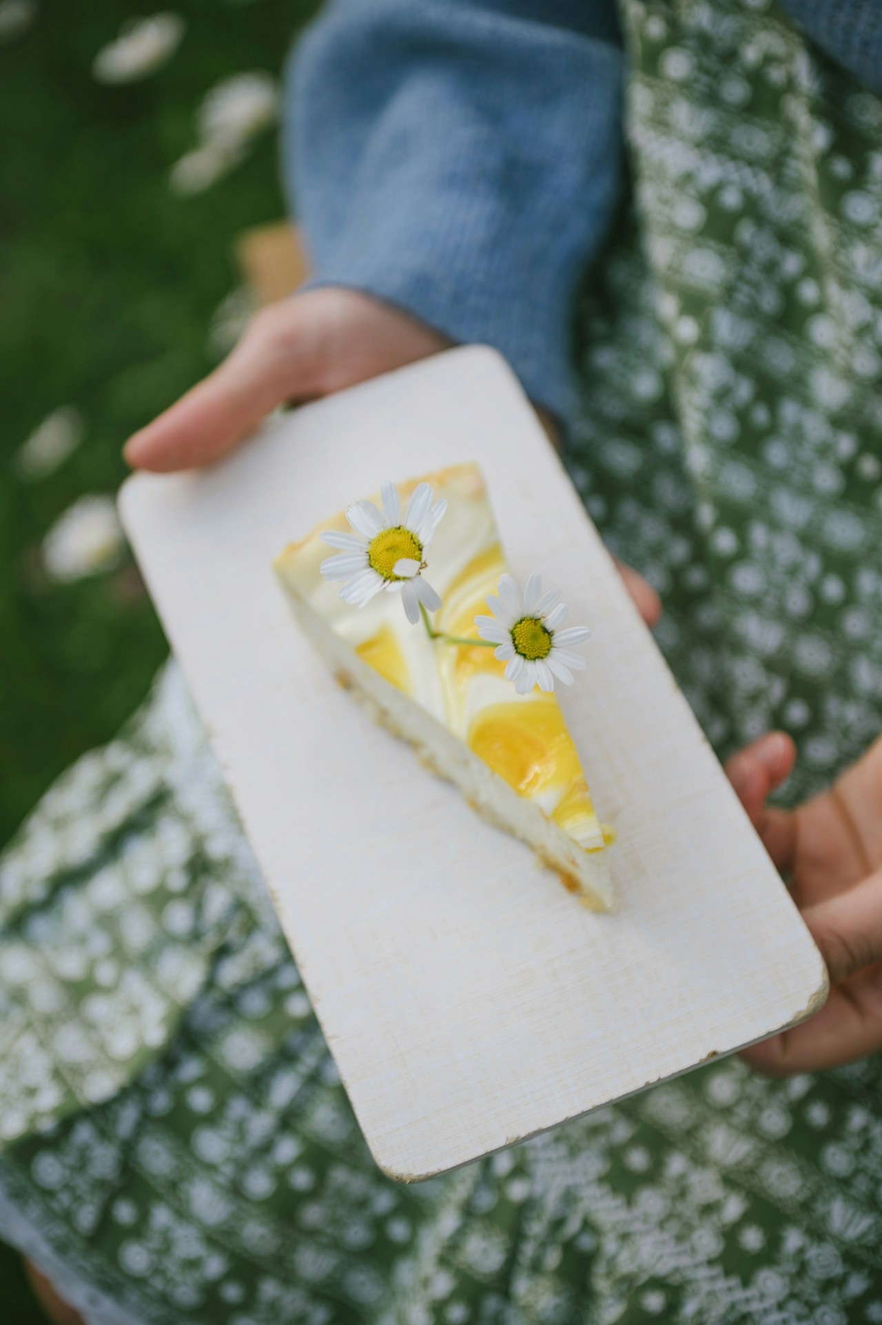 A person holding pressed yellow flowers on a small card.