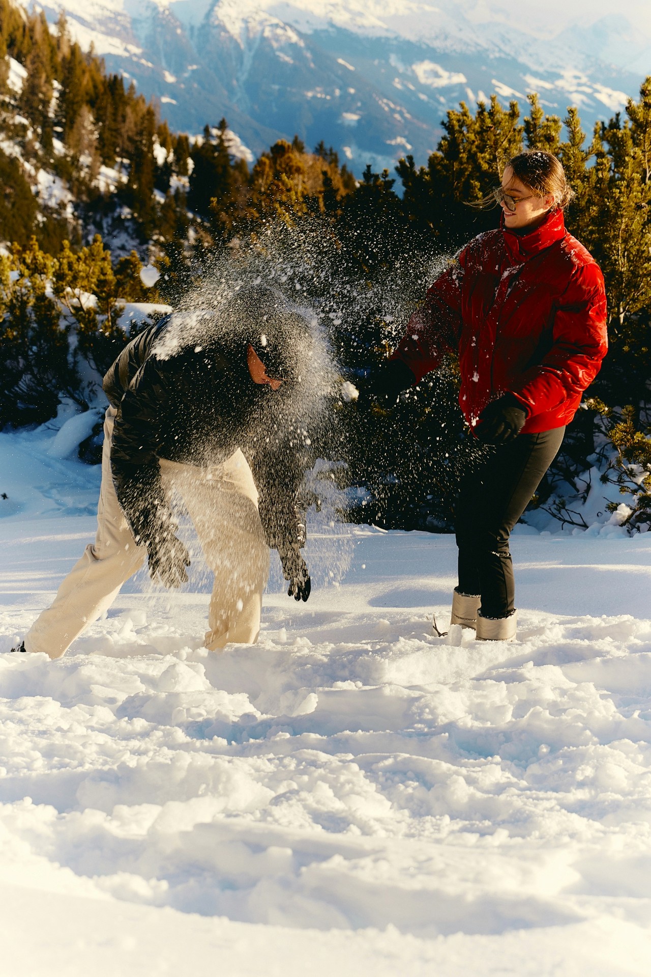 A couple playfully interacting in a snowy setting.