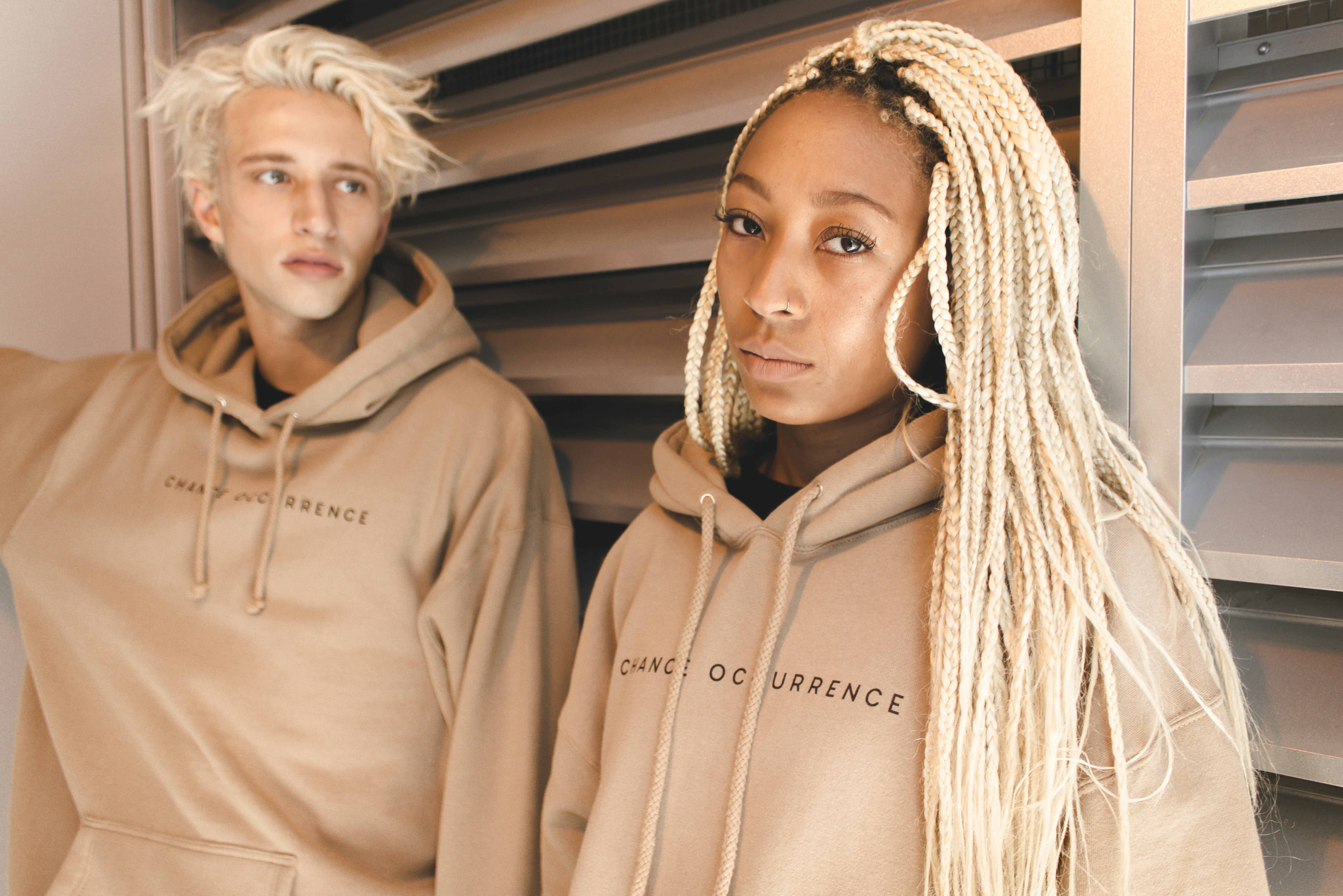 Shot of 2 models standing side by side wearing beige hoodies from orginary garments
