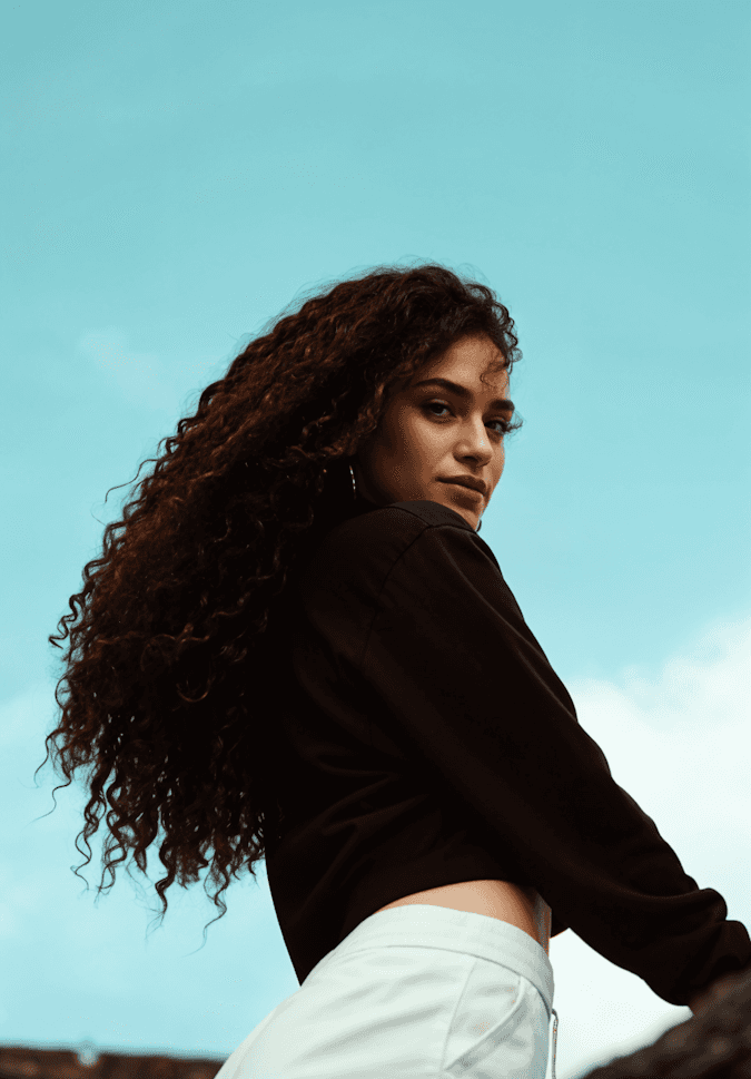 Woman looking back in the black shirt blue sky